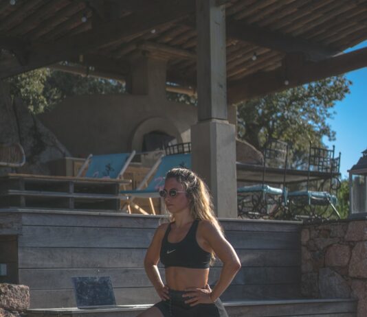 운동 후 근육 회복을 돕는 스트레칭 방법 woman in black sports bra and black shorts sitting on concrete bench during daytime