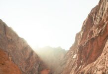 야외 활동으로 건강과 다이어트 함께 달성 a man walking down a dirt road next to a mountain