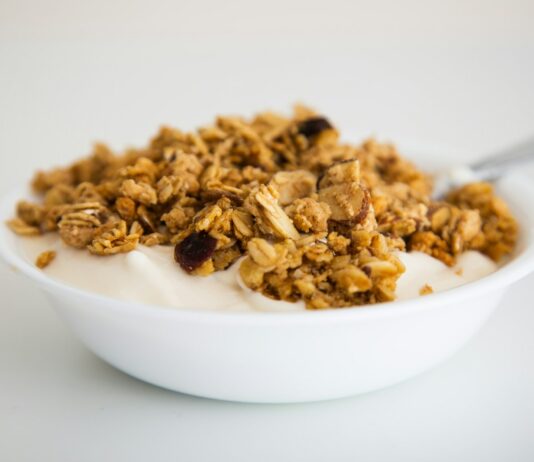 운동 후 빠른 회복을 돕는 식단 계획 a bowl of granola and yogurt with a spoon