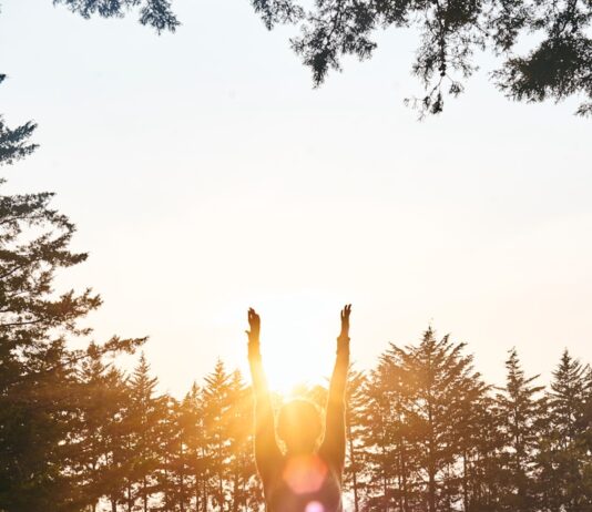 겨울철 필라테스와 요가로 마음 다스리기 woman in black pants and pink shirt standing on green grass field during daytime