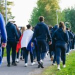 늘어나는 걷기 챌린지 참여… “일상 속 똑똑하게 걸으며 건강 챙겨요” Group of people walking with a flag