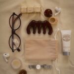 만성피로, 작은 변화로 쌓이는 활력…주목받는 ‘마이크로 루틴’ 실천법 Eyeglasses, comb, lotion, watch, and earbuds arranged flat lay.