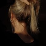 건강한 모발을 위한 새로운 트렌드, 일상 속 실천법은? a woman with her hair in a bun