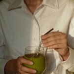 일상을 바꾸는 웰니스 문화, 나만의 작은 변화에서 시작된다 person in white button up shirt holding clear drinking glass with green liquid