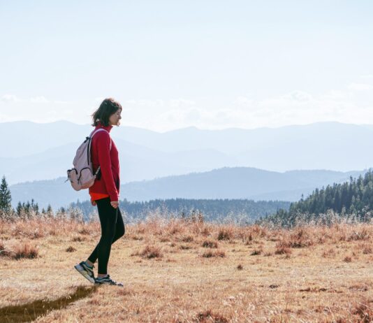 일과 건강, 균형 잡기…직장인을 위한 ‘마이크로 웰니스’ 실천법 a man with a backpack walking across a dry grass covered field