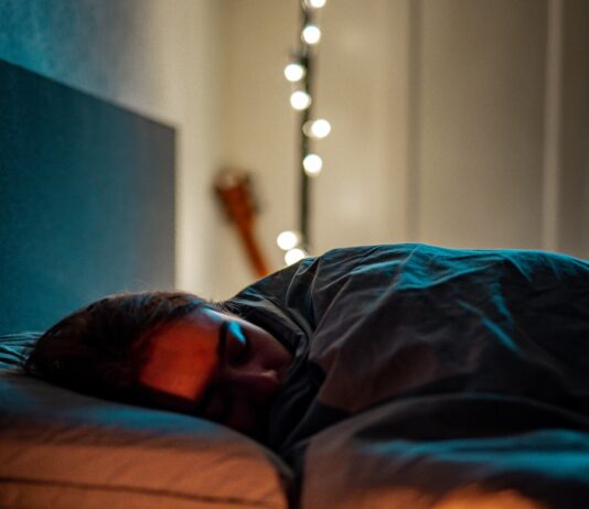 ‘저속노화’의 비밀을 풀다: 건강한 삶을 위한 실천 가이드 a person sleeping on a bed with some candles