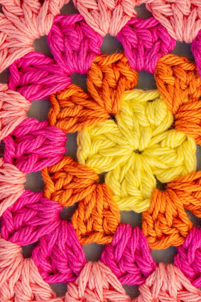 Photo by Cary Bates Vibrant crochet granny square pattern in yellow, orange, and pink.