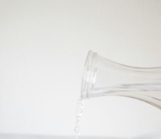 똑똑한 수분 섭취, 건강 지키는 작은 습관의 힘 A person pouring water into a glass on a table